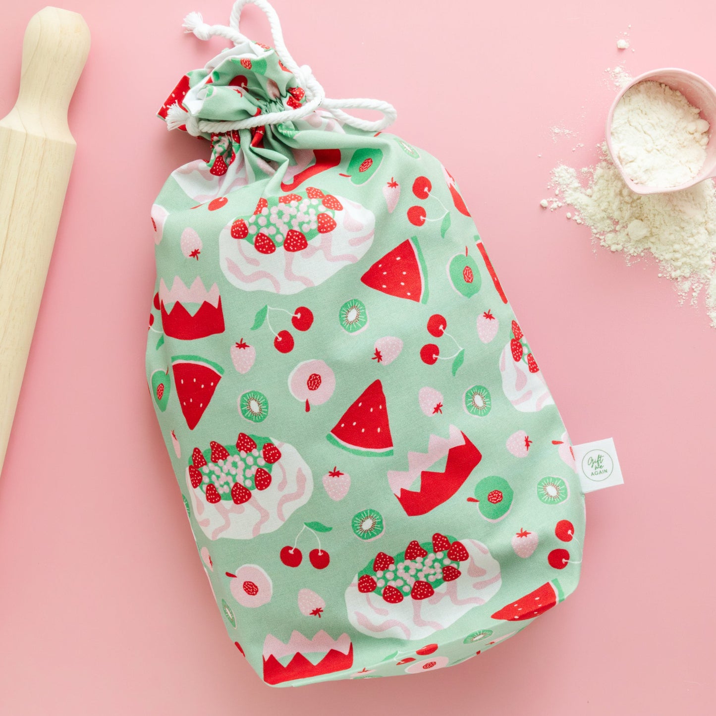 Fabric gift bag with a watermelon, pavlova and fruit pattern on a pink background