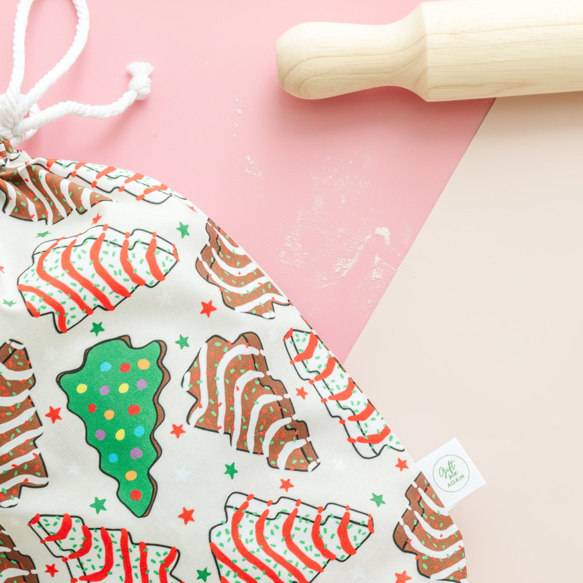 Fabric drawstring bag with Christmas-themed cookie design on a pink background