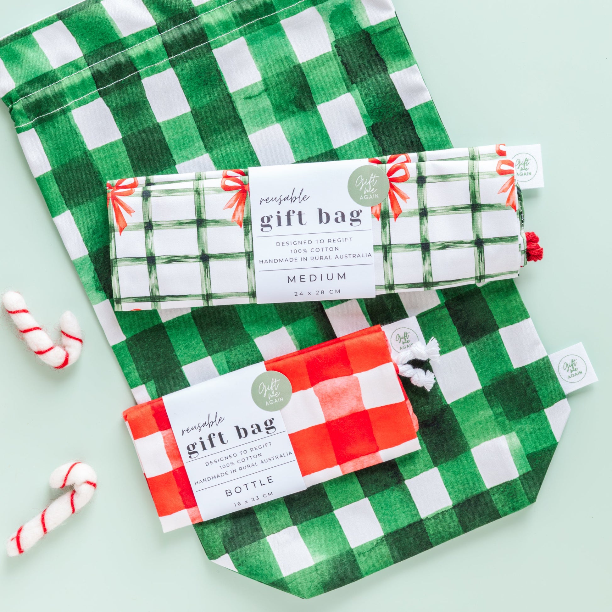 Green and white and red and white checkered gift bags with candy canes on a light green background