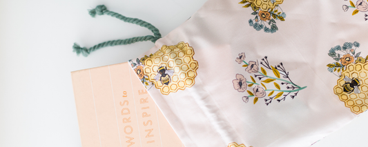Drawstring gift bag with book falling out of it