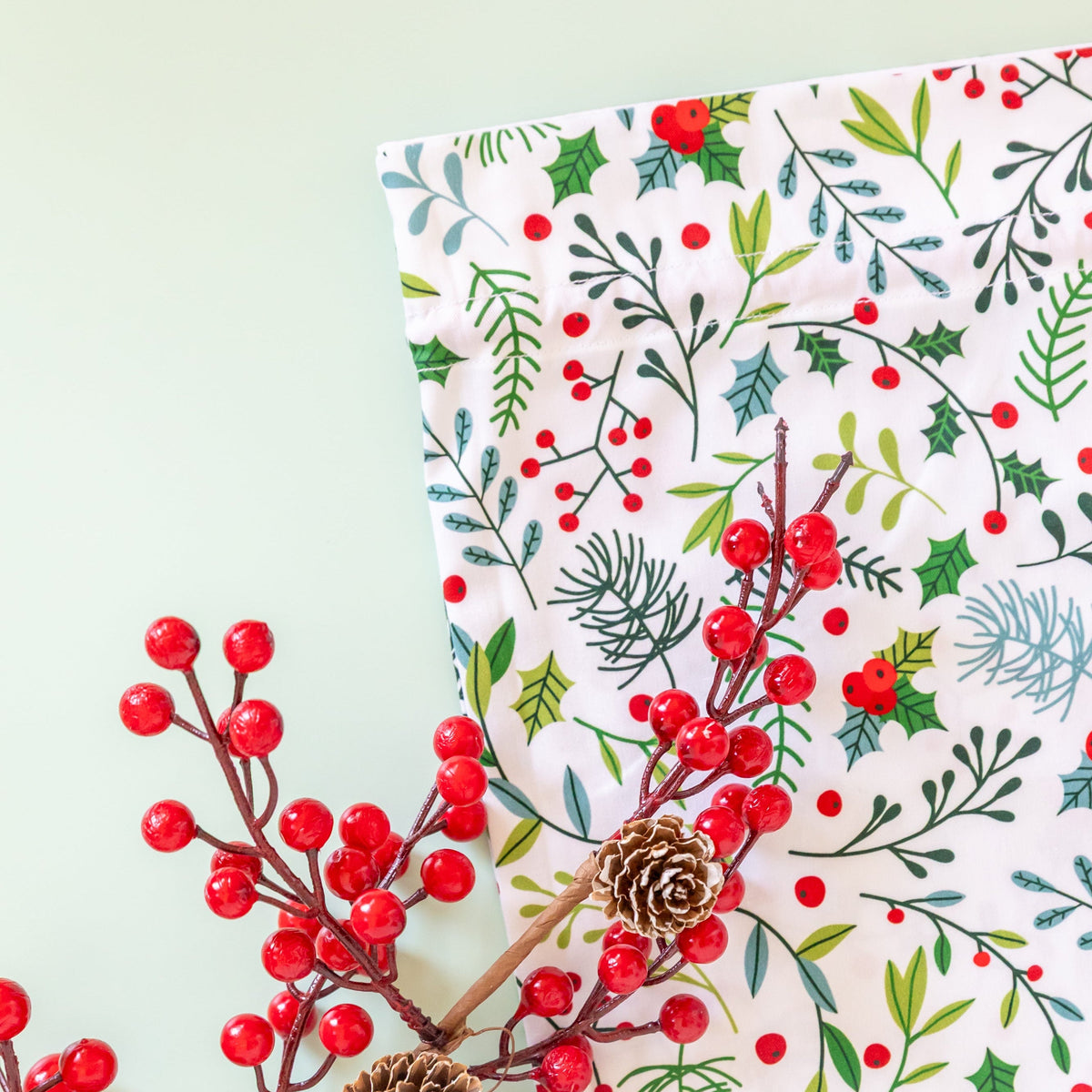 Close-up of Christmas Garden fabric gift bag featuring holly, red berries and festive green foliage.