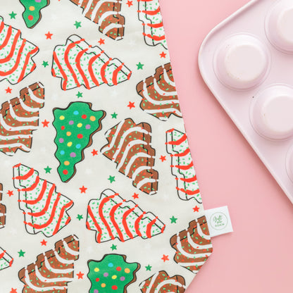 Fabric gift bag with Christmas-cookie themed pattern on a pink background