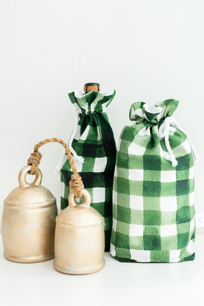 Three green and white check drawstring gift bags with rope handles, arranged on a clean white background.